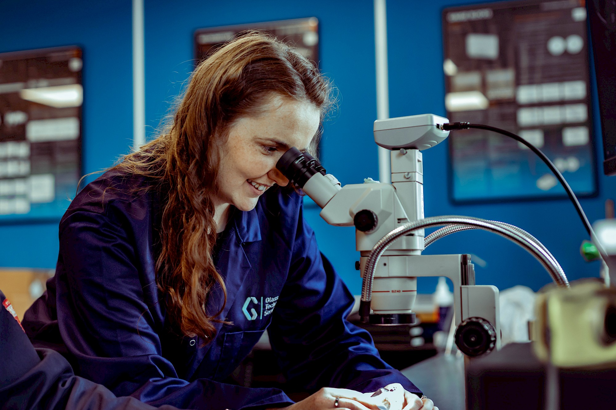 Picture of female analysing glass under micrscope